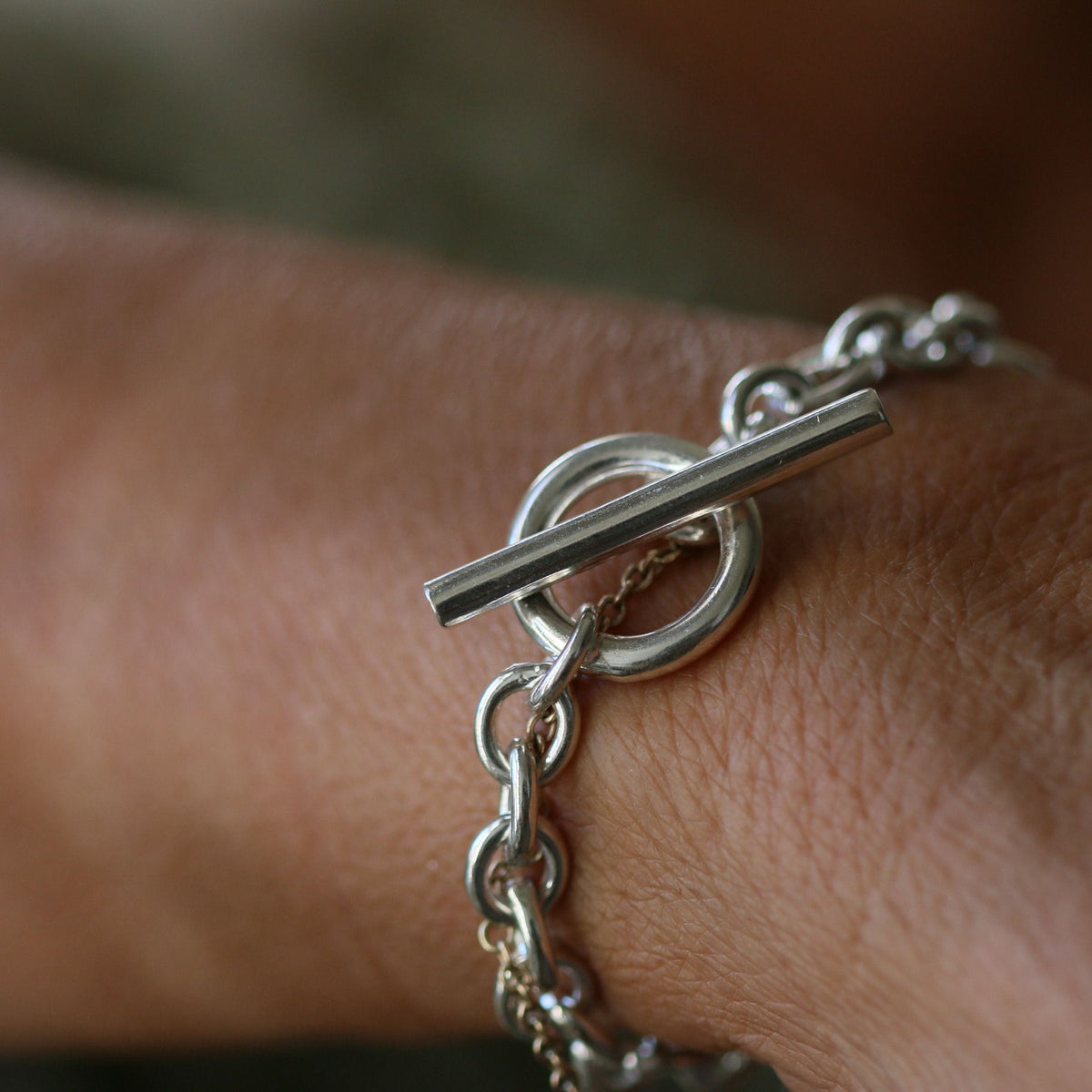 Sterling silver T-bar bracelet on a wrist showing the ring-and-bar fastening