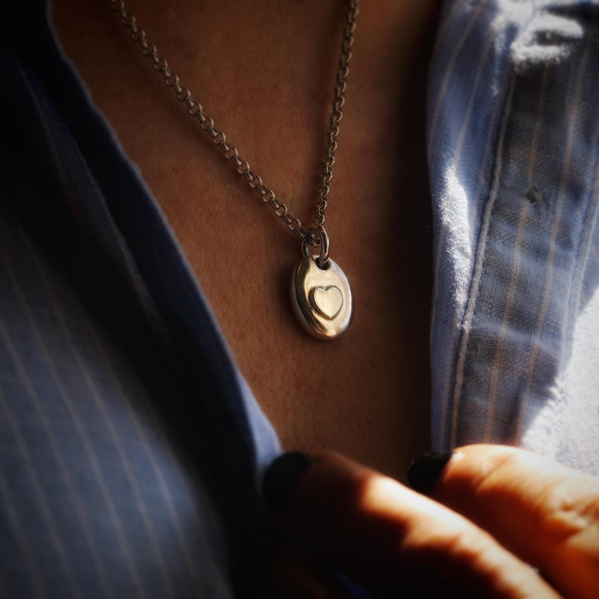 Secret Chamber Pebble Ashes Necklace worn with a blue shirt