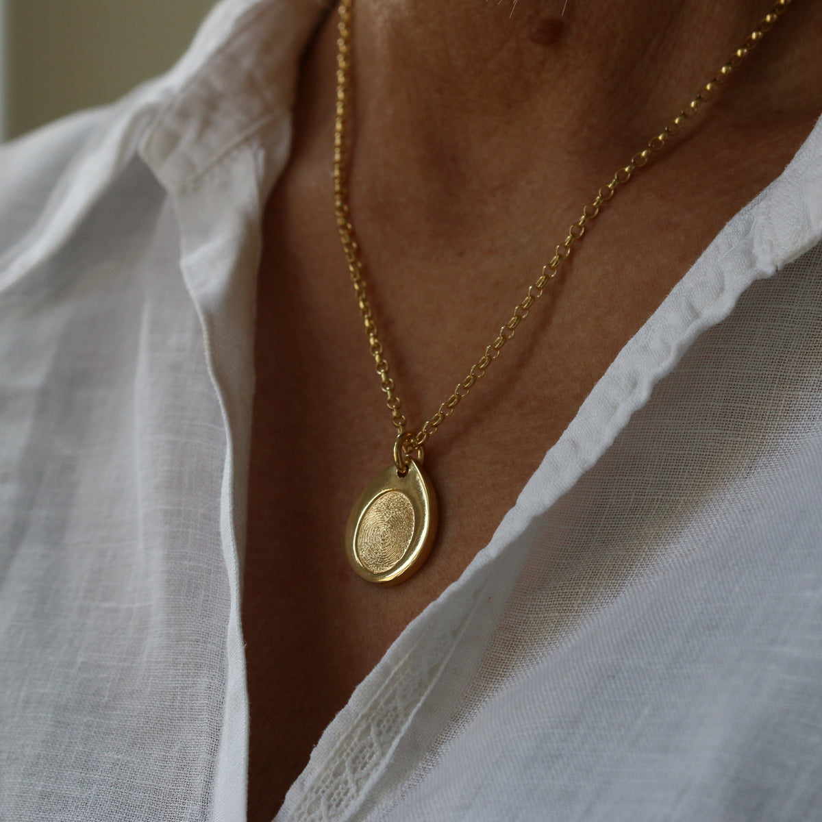 Gold vermeil Teardrop Fingerprint Necklace worn with a white shirt