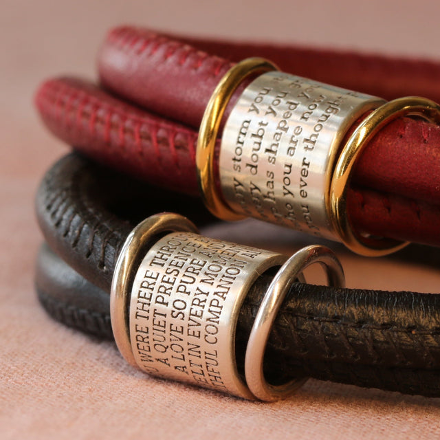 Chapter and Verse engraved silver beads shown on leather bracelets.