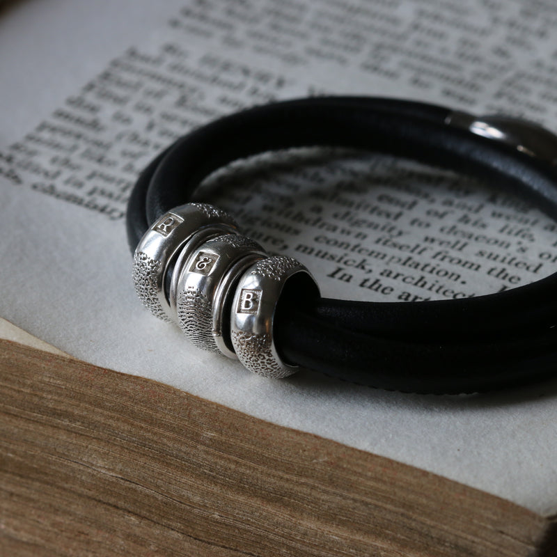 Heirloom silver beads on a black leather bracelet
