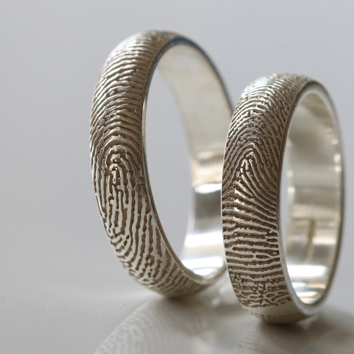 Two silver rings showing the fingerprint detail
