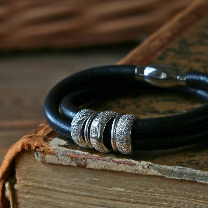Black leather double-wrap bracelet with three sterling silver fingerprint Story Beads