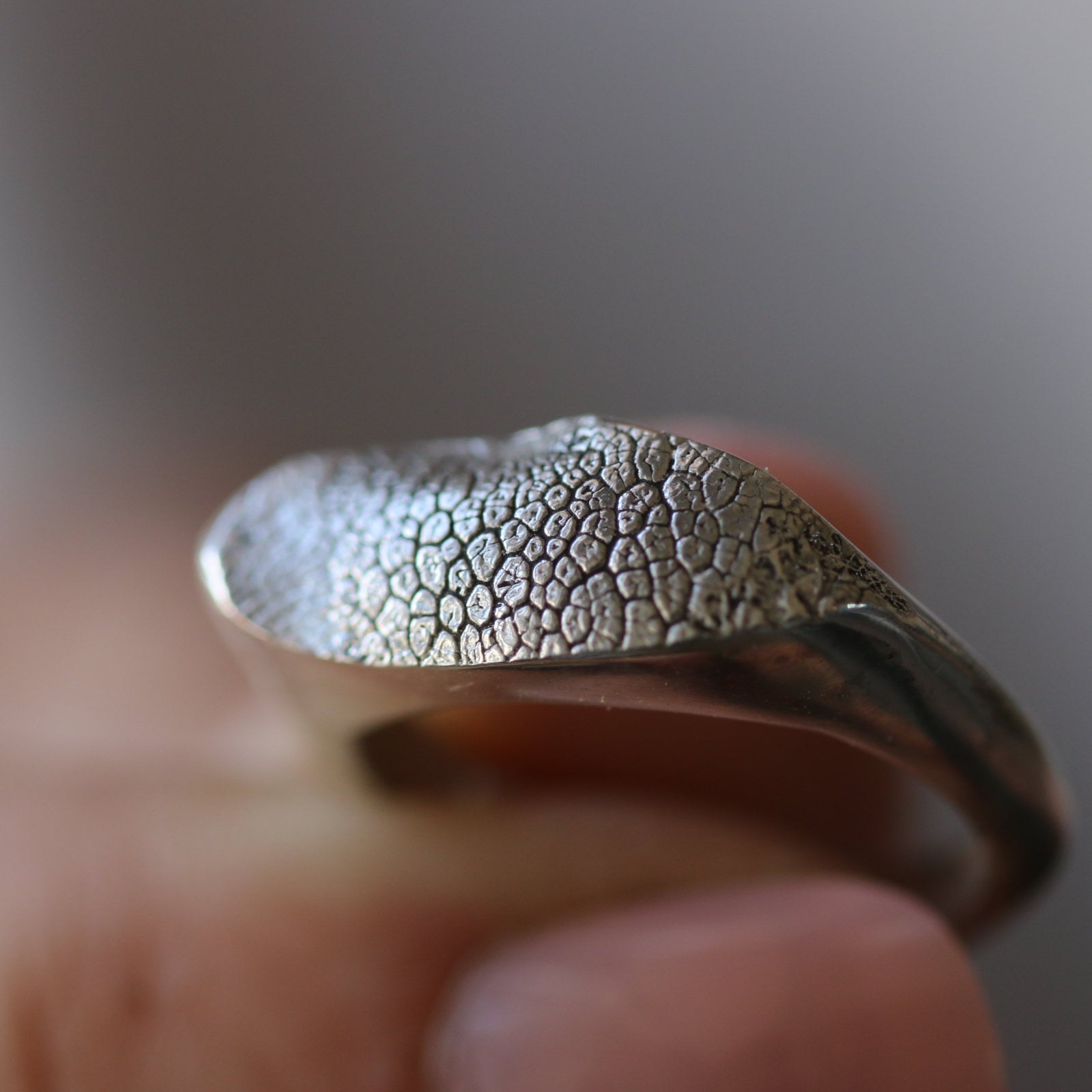 Slim Silver Snozza dog nose print ring in close-up, showing its narrow textured face and slender silver band.