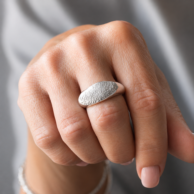 Fuller Snozza dog nose print ring in sterling silver worn on a hand.