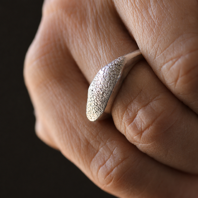 Slim Snozza dog nose print ring in sterling silver worn on a finger.
