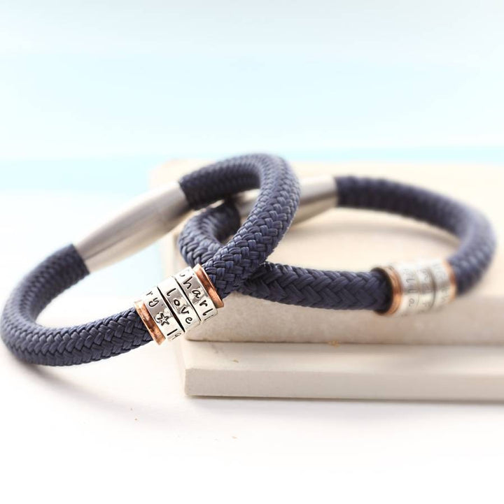 Navy paracord bracelet with three silver rings around a copper core